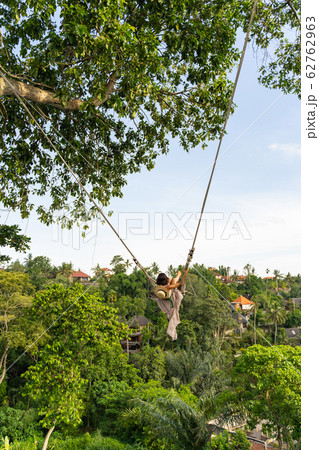 Female flying on swing above jungles stock photo 62762963