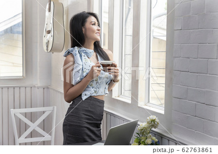 Smiling young Businesswoman looking out the window 62763861