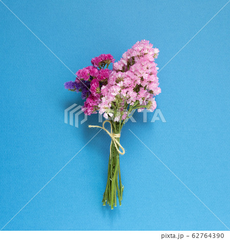 Pink purple statice flowers bouquet on blue background. Floral composition, flat lay, top view 62764390