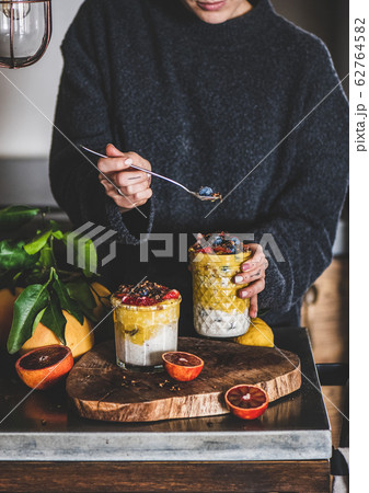 Woman eating muesli with mango smoothie, granola Woman eating muesli with mango smoothie, granola 62764582