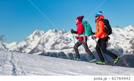 Girls walk with crampons on the snow in the 62764942