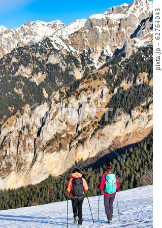 Girl friends during a winter hike on the snow in 62764943