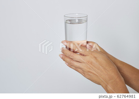 female hand holding a glass of water female hand holding a glass of water 62764981