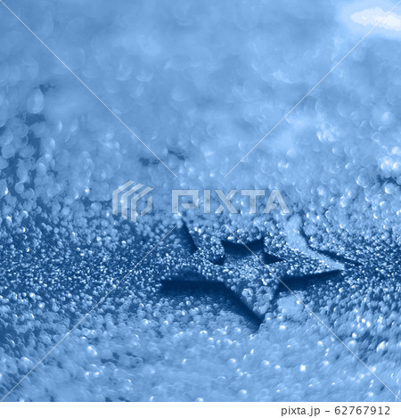Christmas celebration. Abstract background for new year party. Patter of gold stars with lights, bokeh. Trendy blue and calm color. Glitter stars in monochrome color Christmas celebration. Abstract background for new year party. Patter of gold stars with lights, bokeh. Trendy blue and calm color. Glitter stars in monochrome color 62767912