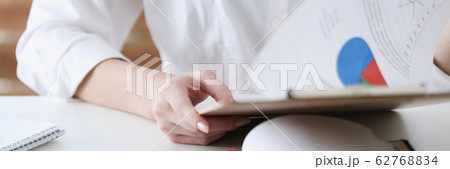 Female hands hold clipboard pad with financial statistics Female hands hold clipboard pad with financial statistics 62768834