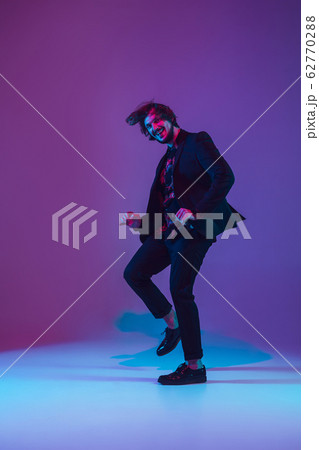 Young caucasian musician dancing in neon light 62770288