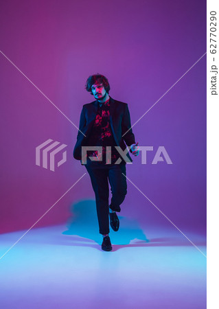 Young caucasian musician dancing in neon light 62770290