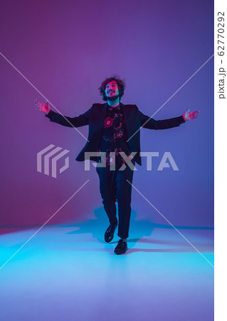 Young caucasian musician dancing in neon light 62770292