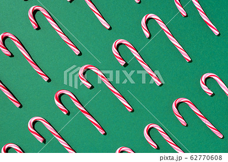 Pattern of Christmas candy cane on green background. Top view. Flat lay. Creative minimal concept. Greeting card on Christmas and New Year. Art composition. Pattern of Christmas candy cane on green background. Top view. Flat lay. Creative minimal concept. Greeting card on Christmas and New Year. Art composition. 62770608