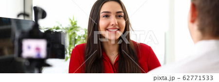 Young woman manager sitting in office and talking with colleague Young woman manager sitting in office and talking with colleague 62771533