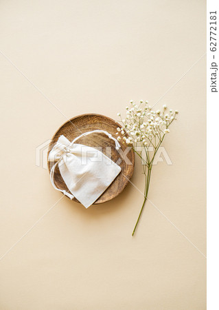 Small linen bag in wooden plate on beige background Small linen bag in wooden plate on beige background 62772181