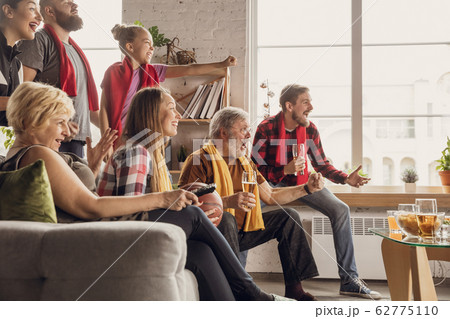 Excited, happy big family team watch football, soccer match together on the couch at home 62775110