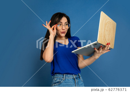 Caucasian woman's portrait isolated on blue studio background 62776371