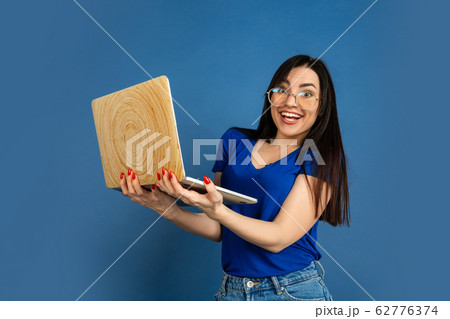 Caucasian woman's portrait isolated on blue studio background 62776374