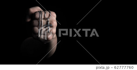 Silver crucifix or cross pendant and necklace on body or hand studio shot black color background which represent to praying for god or jesus for christian religion people who have faith Silver crucifix or cross pendant and necklace on body or hand studio shot black color background which represent to praying for god or jesus for christian religion people who have faith 62777760