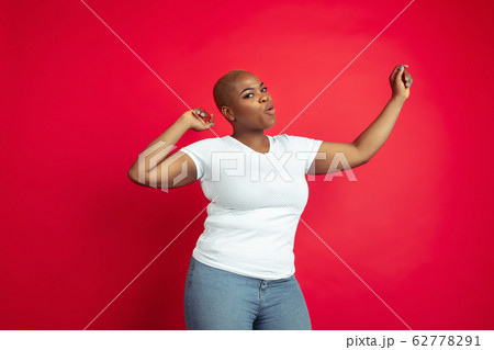 African-american young woman's portrait on red background 62778291