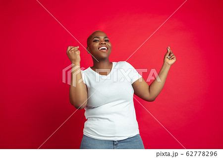 African-american young woman's portrait on red background 62778296