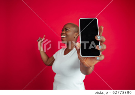 African-american young woman's portrait on red background 62778390