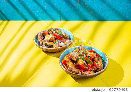 Hawaiian pinapple chicken in blue bowls on yellow 62779498