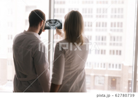 Two confident doctor discuss X-ray of patient in meeting room 62780739