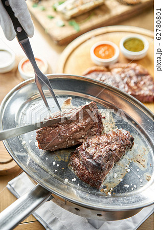 Grilled fillet steaks. A piece of meat cut in two. Barbecue restaurant menu. On a metal plate with coal. Chateaubriand Steak Grilled fillet steaks. A piece of meat cut in two. Barbecue restaurant menu. On a metal plate with coal. Chateaubriand Steak 62780801