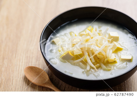 Rice soup with mung bean sprouts in a bowl and wooden spoon,Asian vegan food Rice soup with mung bean sprouts in a bowl and wooden spoon,Asian vegan food 62787490