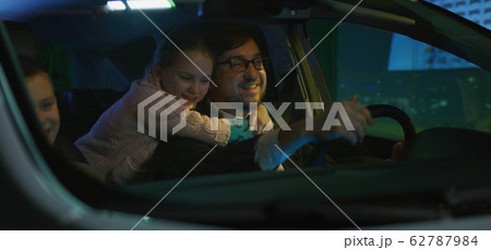 Father driving his children home at night 62787984