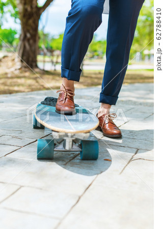 Businessman person leather boot riding skate board Businessman person leather boot riding skate board 62788410