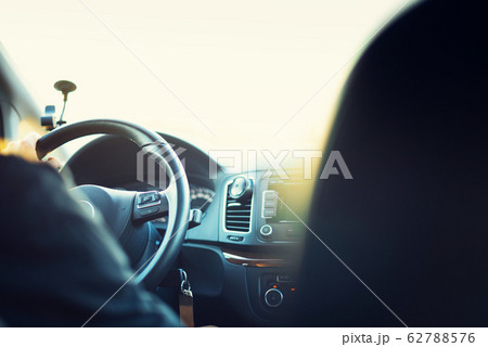 Young man driving his car. Blurred travel background with vintage toned effect, sunny bokeh. Trip, road concept. Driving test, exam 62788576