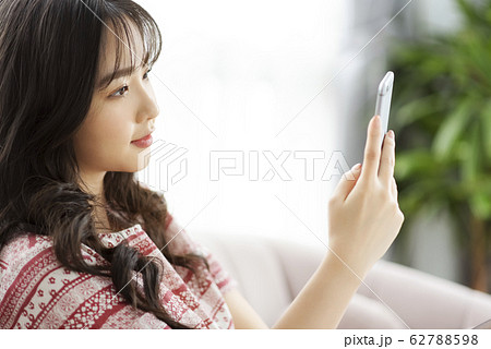 A young lady with a smartphone on the sofa A young lady with a smartphone on the sofa 62788598