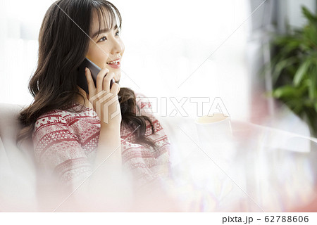 A young lady with a smartphone on the sofa 62788606