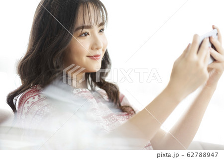 A young lady with a smartphone on the sofa A young lady with a smartphone on the sofa 62788947