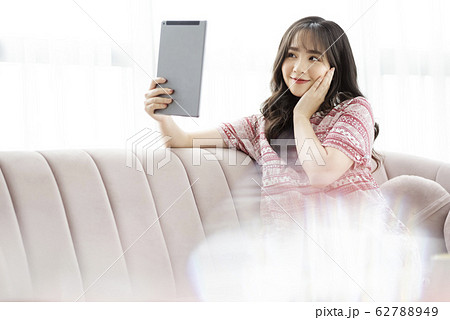A young lady with a smartphone on the sofa 62788949