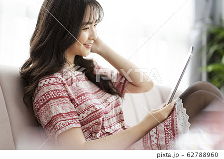 A young lady with a smartphone on the sofa 62788960