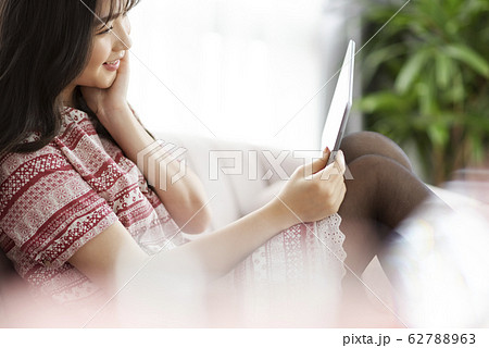A young lady with a smartphone on the sofa 62788963
