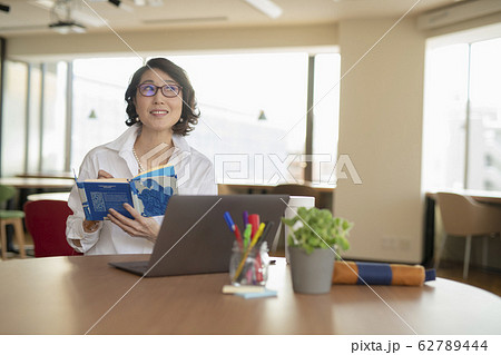 シェアオフィスで手帳にメモをとる女性 62789444