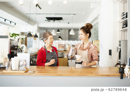 談笑しながらカウンターでコーヒーを淹れる女性 62789648