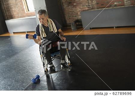 車椅子に乗りダンベルを使うシニアの男性 車椅子に乗りダンベルを使うシニアの男性 62789696