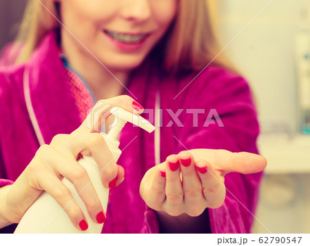 Woman applying hand cream on hands Woman applying hand cream on hands 62790547