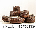 Delicious chocolate dietary treats for vegans made from natural ingredients. Candy and raisin cookies, sprinkled with coconut, on a white plate. Light background with place for text. Selective focus 62791589