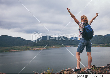 Happy woman standing near the lake at the day Happy woman standing near the lake at the day 62793122