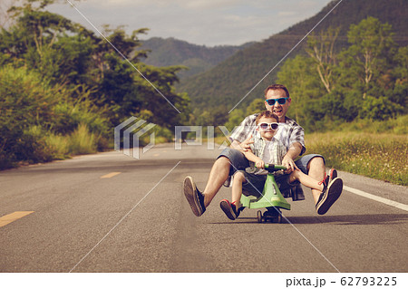 Father and son playing on the road at the day Father and son playing on the road at the day 62793225