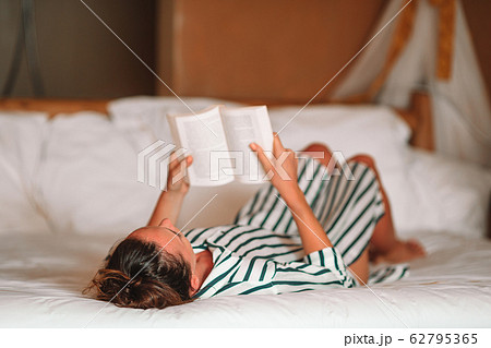 Beautiful woman reading book in bed relaxing Beautiful woman reading book in bed relaxing 62795365