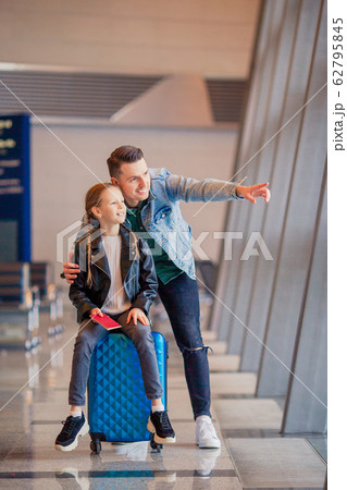 Happy family with luggage and boarding pass at airport waiting for boarding 62795845
