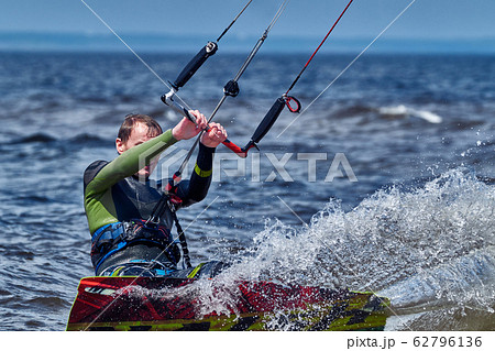 A male kiter slides on the surface of the water. 62796136
