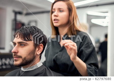 Handsome blue eyed man sitting in barber shop. Handsome blue eyed man sitting in barber shop. 62797680