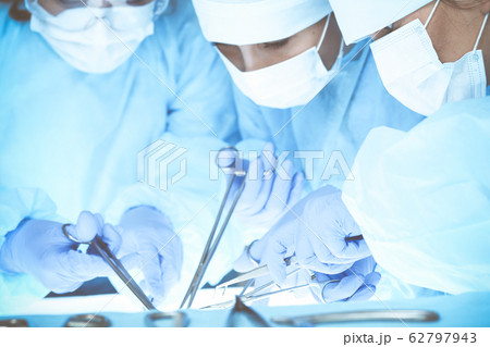 Close-up of medical team performing operation. Group of surgeons at work are busy of patient. Medicine, veterinary or healthcare and emergency in hospital 62797943