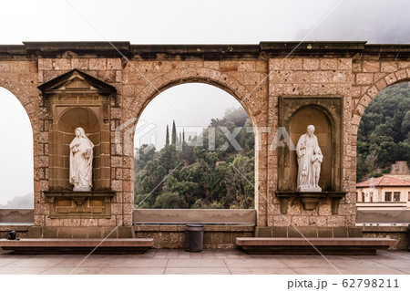 Arch of Montserrat Monastery in foggy winter day. Hiking religious destination. 62798211