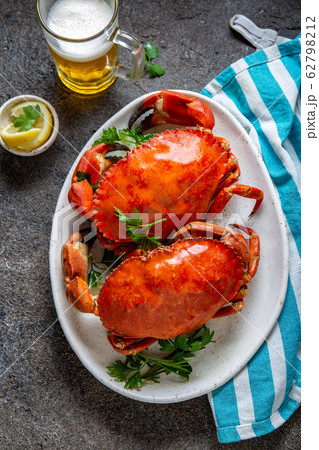 Whole cooked  crabs on white plate with lemon and 62798212