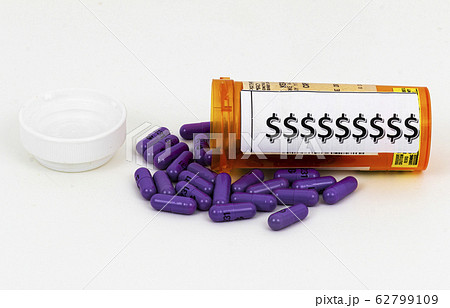 Purple pills spilling our of prescription bottle 62799109